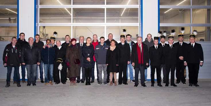 Photo : Groupe de 24 hommes et femmes, certains en combinaison traditionelle de travail, prise de haut